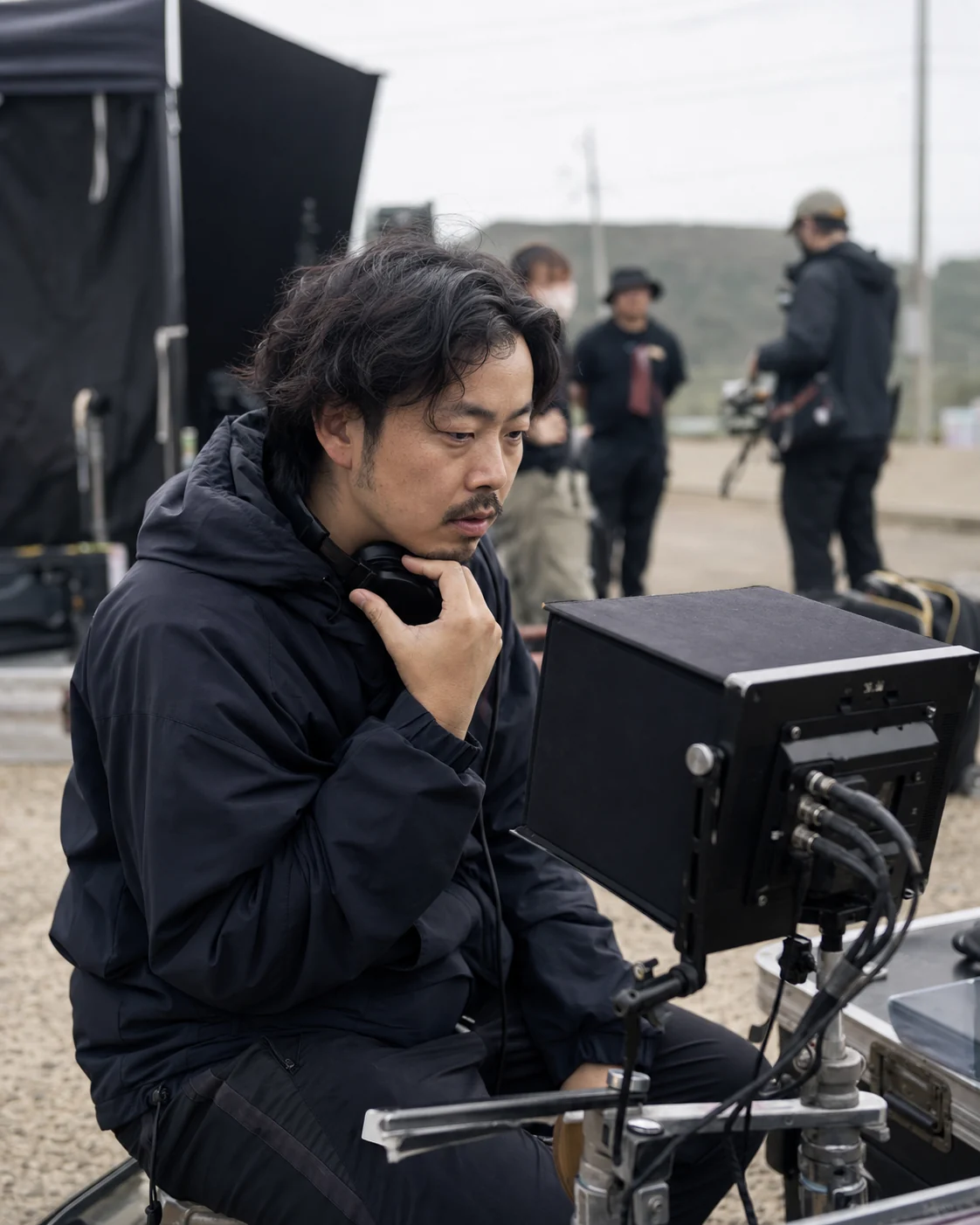 A film crew member reviewing footage on a production monitor